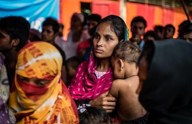 A mother and child line up for relief good in Kutapalong camp. Atom Araullo
